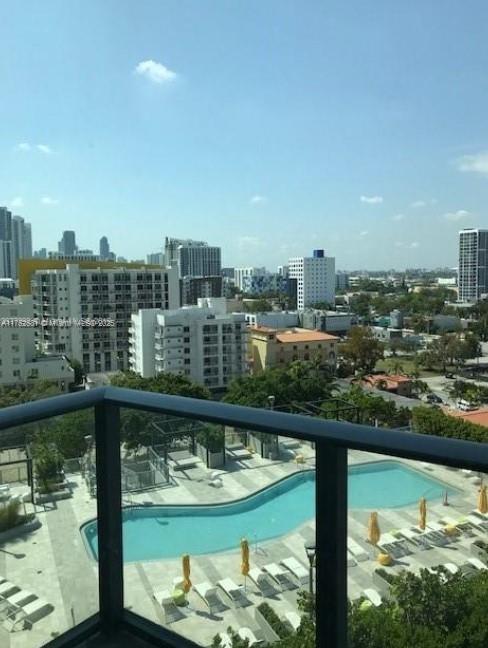 view of pool with central air condition unit and a view of city