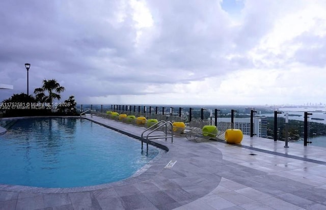 view of swimming pool with a patio and fence