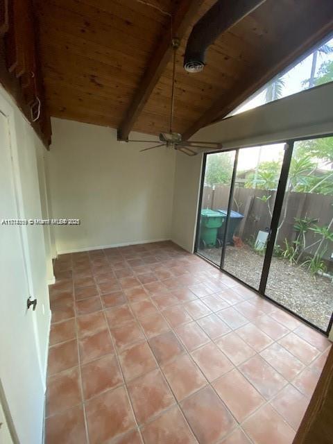 interior space featuring light tile patterned floors, a ceiling fan, wooden ceiling, and vaulted ceiling with beams