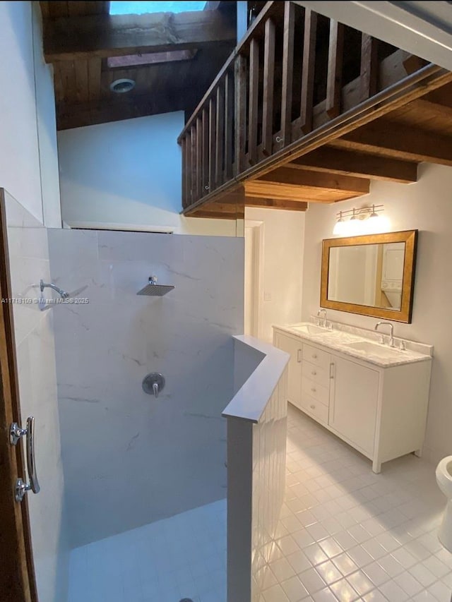 bathroom featuring double vanity, a marble finish shower, and a sink