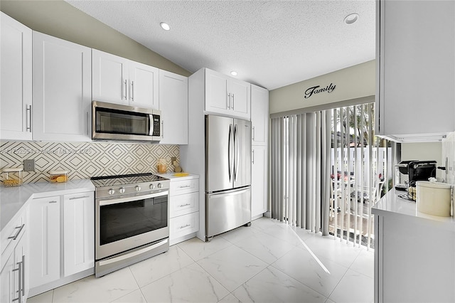 kitchen with marble finish floor, stainless steel appliances, light countertops, and white cabinets