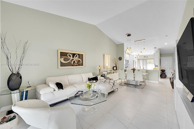 living area featuring marble finish floor, vaulted ceiling, and baseboards