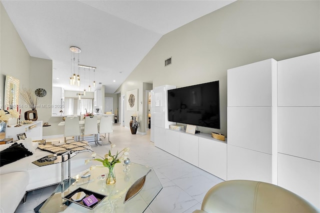 living room featuring vaulted ceiling, marble finish floor, and visible vents