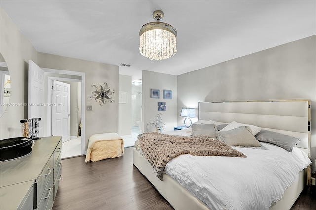 bedroom with dark wood-style floors, visible vents, and a chandelier