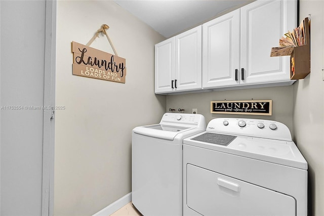 clothes washing area with cabinet space, independent washer and dryer, and baseboards