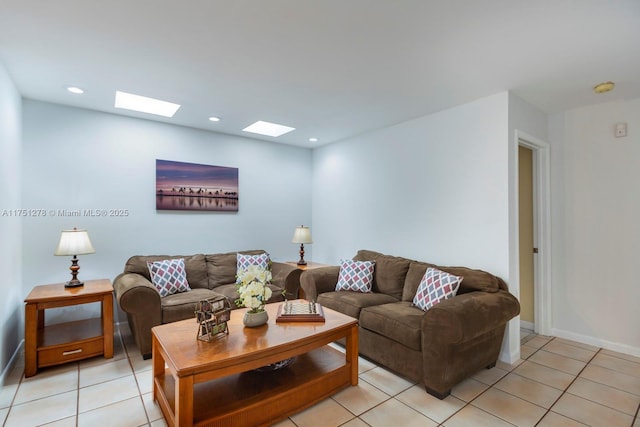 living room featuring baseboards, light tile patterned flooring, a skylight, and recessed lighting