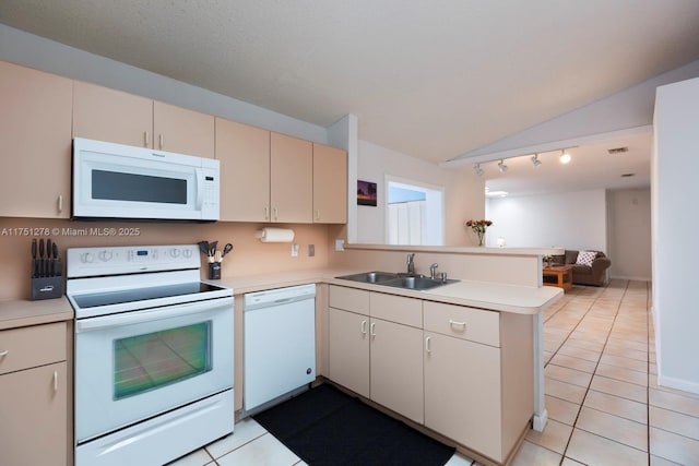 kitchen with a peninsula, white appliances, a sink, and light countertops