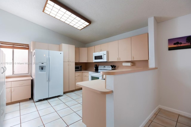 kitchen featuring cream cabinetry, light tile patterned floors, light countertops, white appliances, and a peninsula