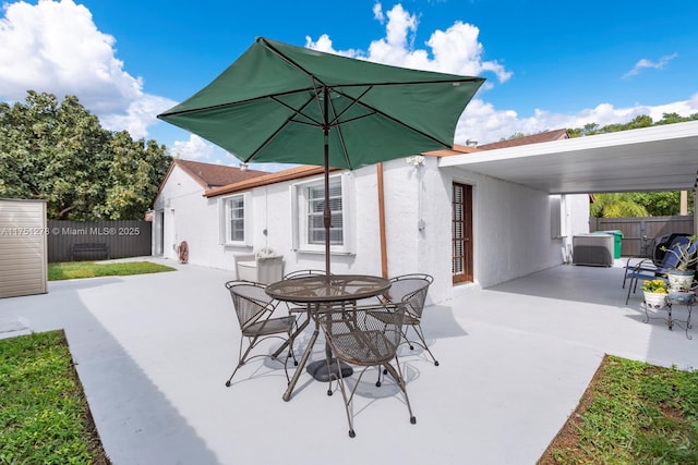 view of patio / terrace with central AC unit, outdoor dining area, and a fenced backyard