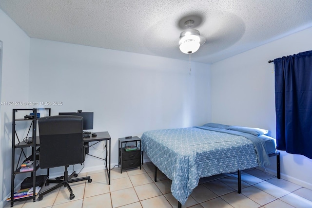 bedroom featuring a textured ceiling, baseboards, and light tile patterned floors