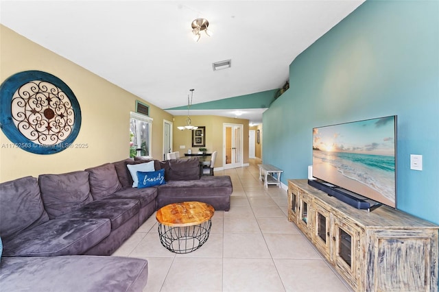 living area featuring light tile patterned floors, baseboards, visible vents, and vaulted ceiling