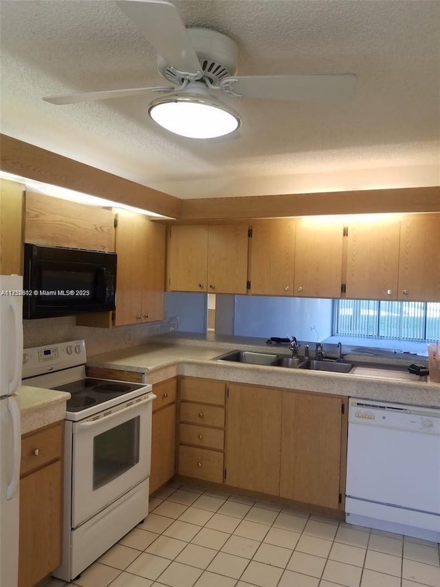 kitchen with a textured ceiling, light countertops, white appliances, and a sink