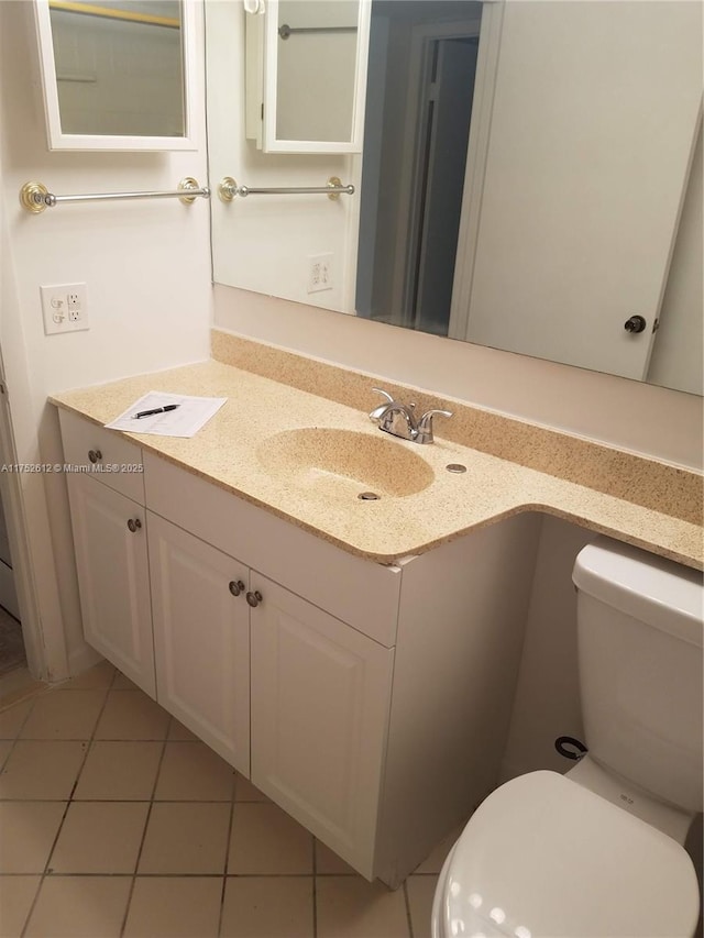 bathroom featuring toilet, vanity, and tile patterned floors