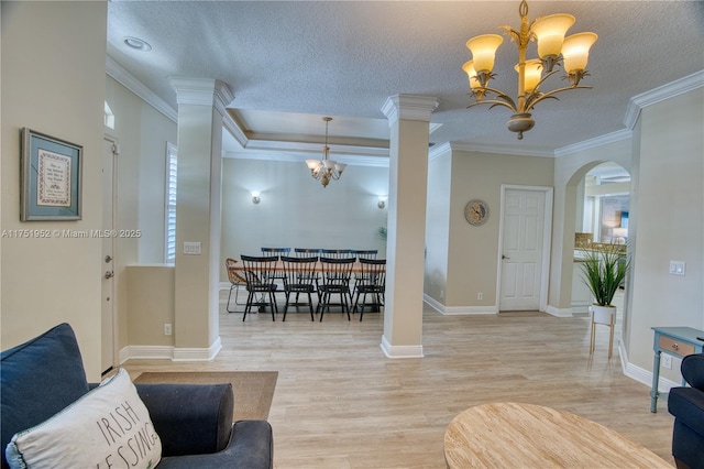 living room featuring crown molding, a notable chandelier, light wood-style flooring, and a textured ceiling