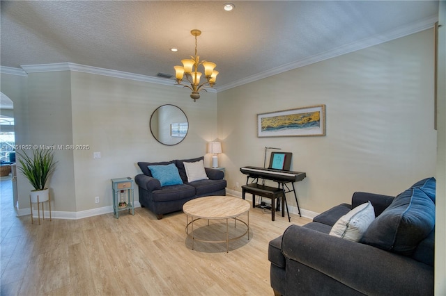 living room with a notable chandelier, baseboards, light wood-style flooring, and crown molding