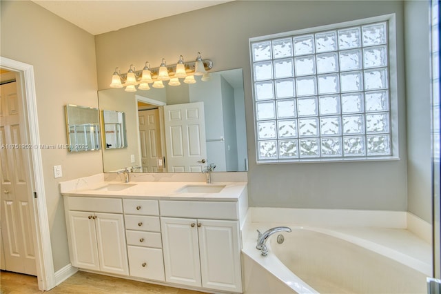 full bath featuring a closet, double vanity, a sink, and a bath