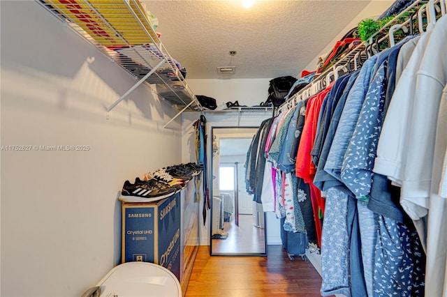 walk in closet with wood finished floors