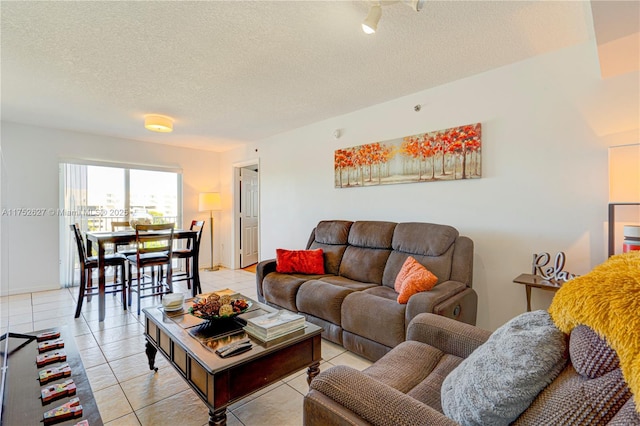 living room featuring a textured ceiling, baseboards, and light tile patterned floors