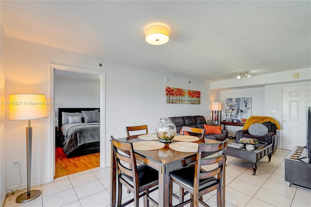 dining area with light tile patterned floors and a textured ceiling