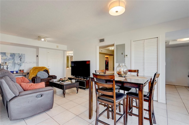 dining area featuring electric panel, visible vents, and light tile patterned floors