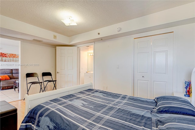 bedroom with a closet, visible vents, and a textured ceiling