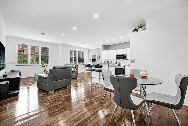 dining area featuring a healthy amount of sunlight, crown molding, and wood finished floors