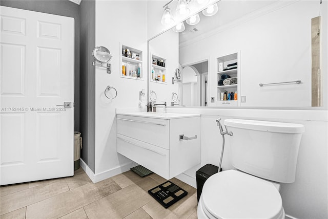 bathroom with baseboards, crown molding, vanity, and toilet