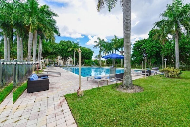 community pool featuring a yard, a patio area, and fence