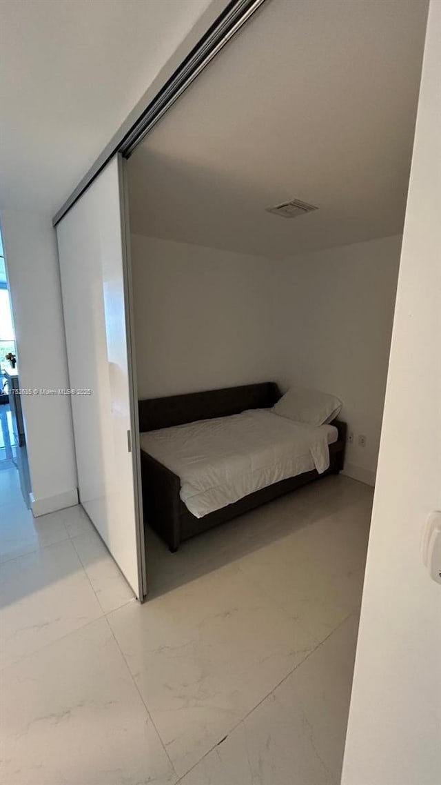 unfurnished bedroom with marble finish floor and visible vents