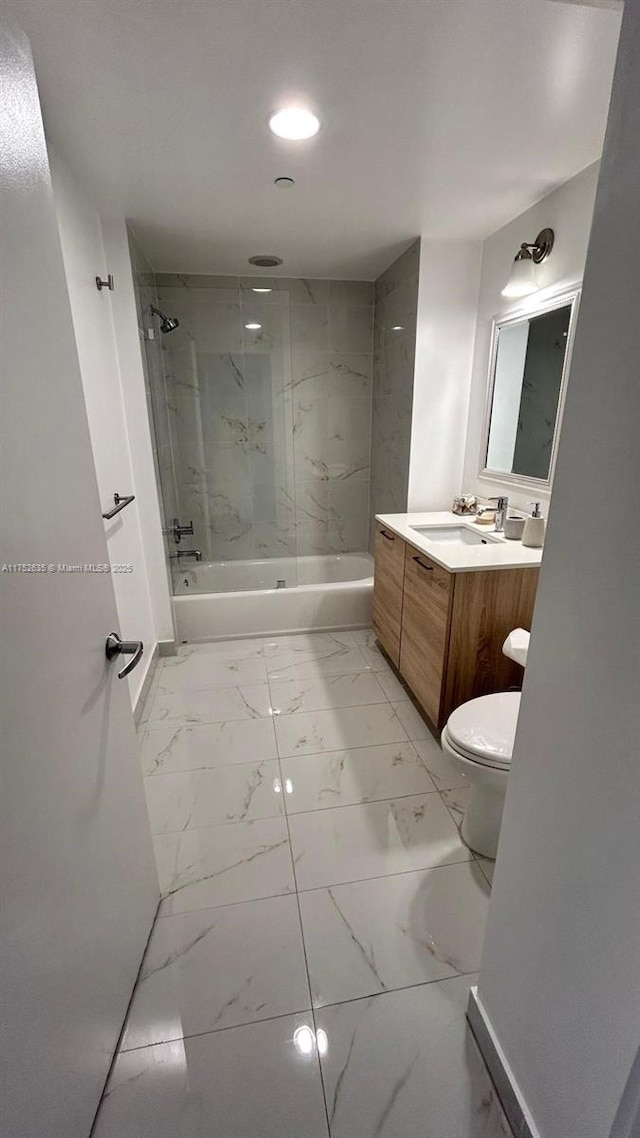 bathroom featuring toilet, marble finish floor, washtub / shower combination, and vanity