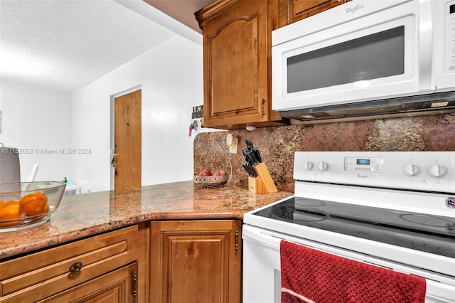 kitchen featuring light stone counters, backsplash, brown cabinetry, a textured ceiling, and white appliances