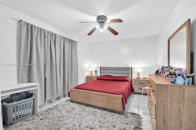 bedroom with a ceiling fan, a textured ceiling, and light tile patterned flooring