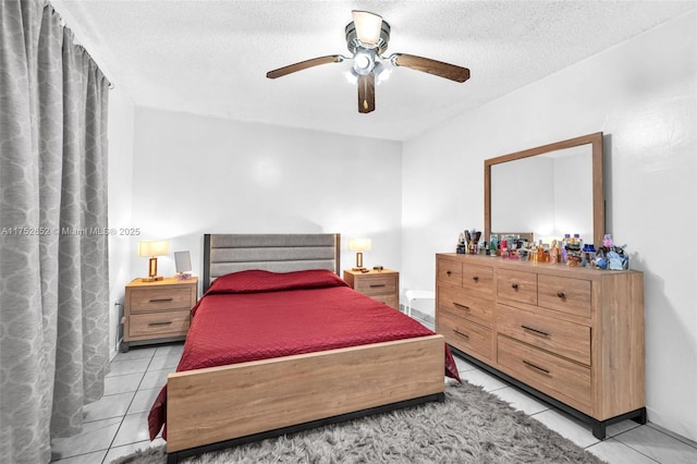 bedroom featuring light tile patterned floors, ceiling fan, and a textured ceiling