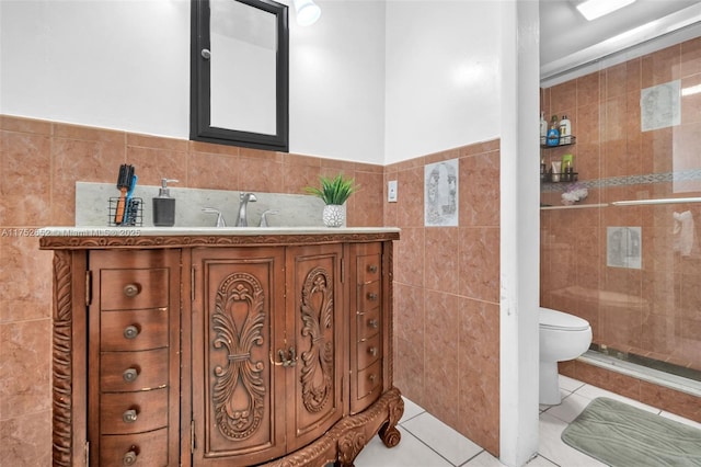 full bathroom featuring tile walls, toilet, vanity, a shower stall, and tile patterned floors