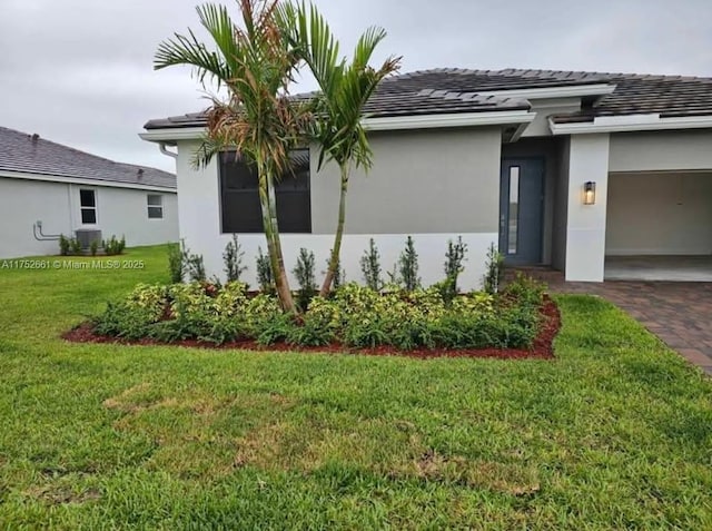 view of home's exterior featuring decorative driveway, a yard, an attached garage, and stucco siding