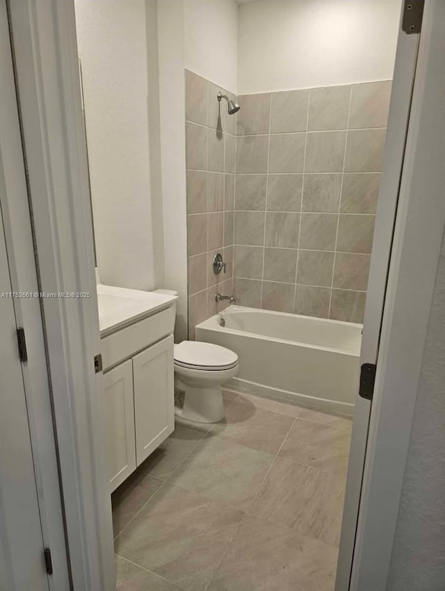 bathroom with washtub / shower combination, tile patterned flooring, vanity, and toilet