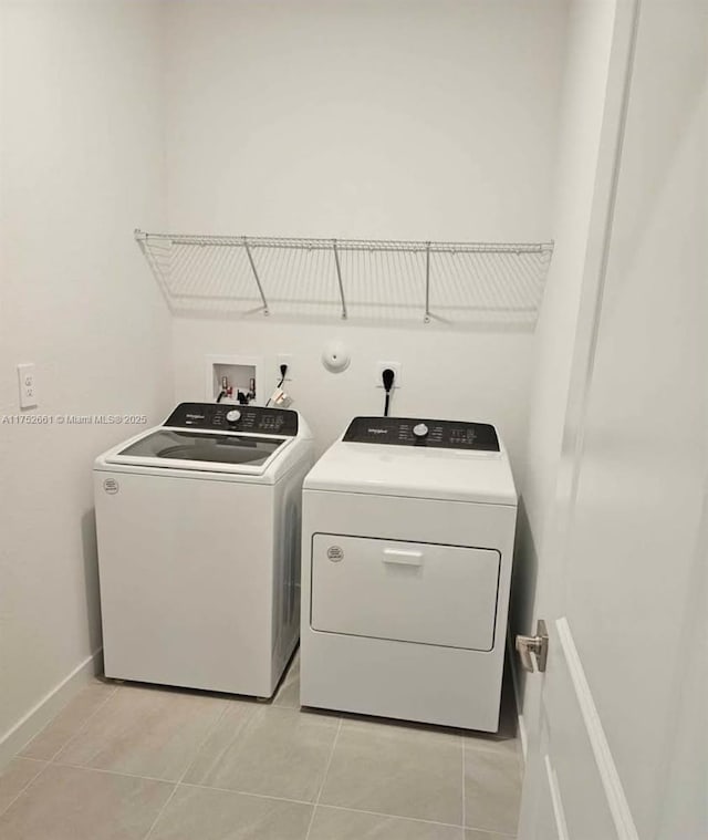 laundry area featuring laundry area, independent washer and dryer, baseboards, and light tile patterned floors