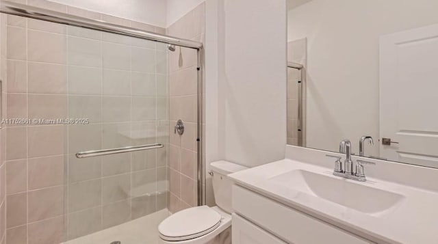 full bathroom with a tile shower, vanity, and toilet