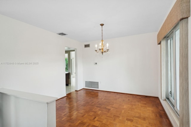 spare room with baseboards, visible vents, and an inviting chandelier