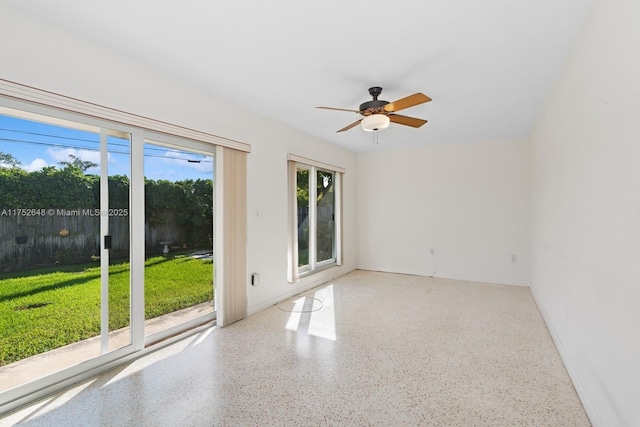 empty room with a ceiling fan and speckled floor