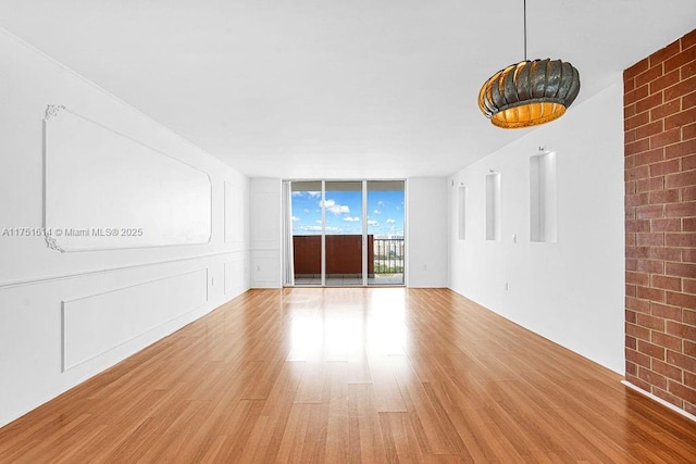 empty room with light wood-type flooring and floor to ceiling windows