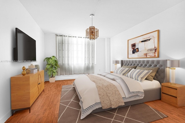 bedroom with a chandelier and wood finished floors