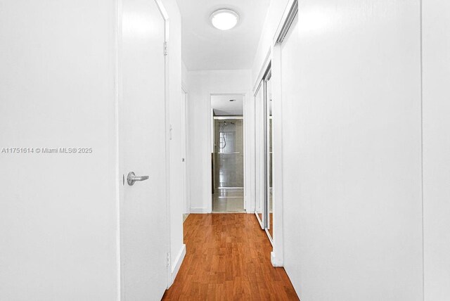 hall with baseboards and wood finished floors