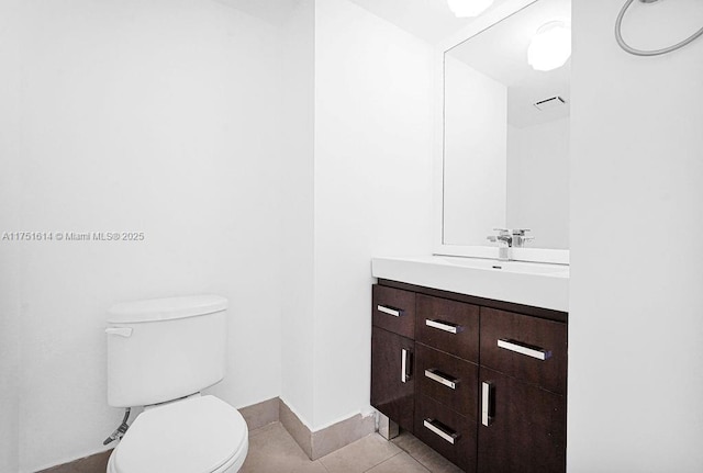 half bath featuring tile patterned flooring, baseboards, vanity, and toilet