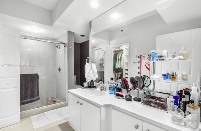 bathroom with a stall shower, tile patterned floors, and vanity