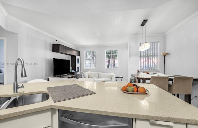 kitchen featuring ornamental molding, light stone counters, hanging light fixtures, a sink, and stainless steel dishwasher