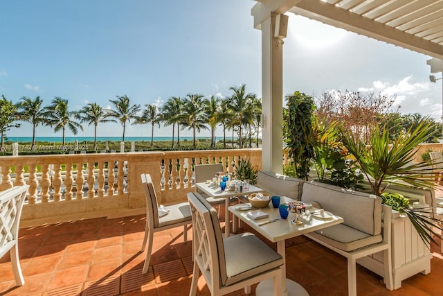 view of patio with a water view, a pergola, and outdoor dining space