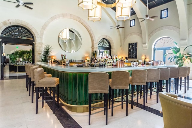 bar with a towering ceiling, a community bar, and a ceiling fan