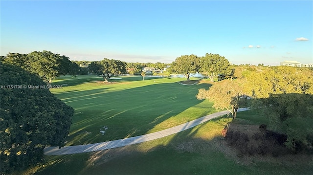 view of home's community featuring view of golf course and a yard