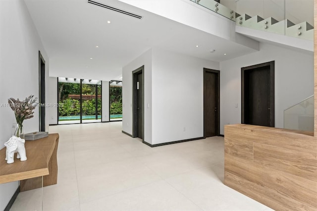 interior space with a wall of windows, recessed lighting, visible vents, and baseboards